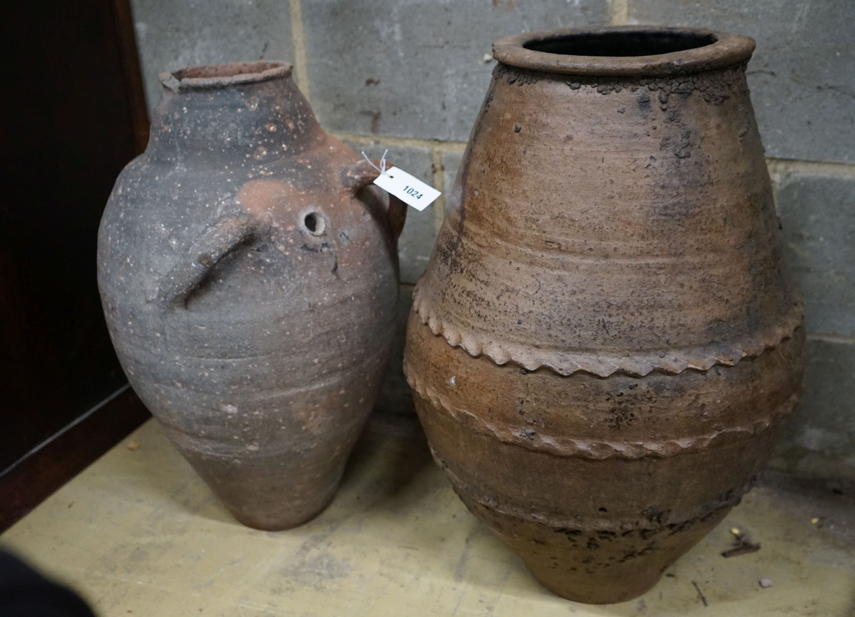 Two Greek style earthenware oil jars, largest height 67cm